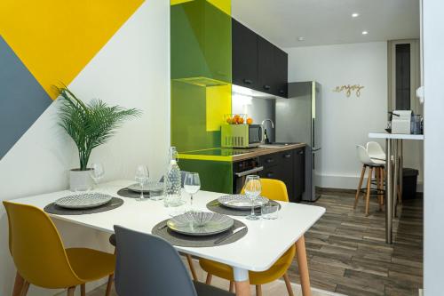 una cucina e una sala da pranzo con tavolo bianco e sedie gialle di La Bulle Paloise, Appartement, hyper-centre a Pau