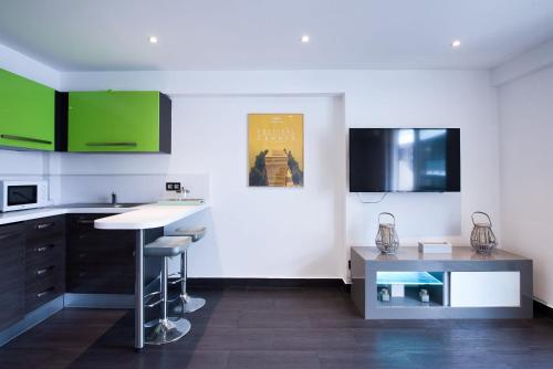 une cuisine avec des placards verts et un comptoir dans l'établissement LE VENITIA studio raffiné avec balcon mignon, pour votre séjour à deux, à Cannes