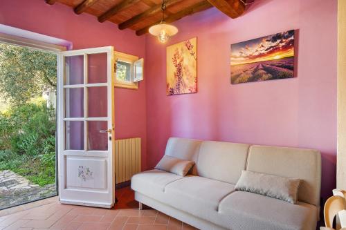 a living room with a couch and a pink wall at Casa Lavanda Country House in Camaiore
