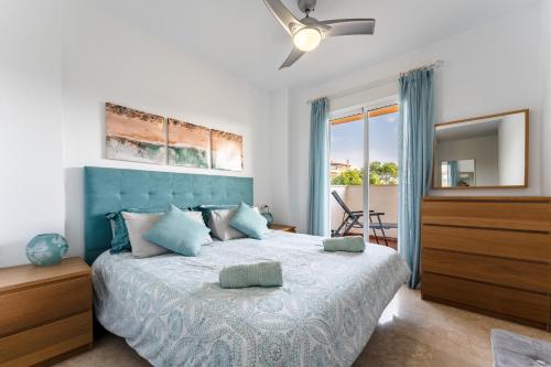a bedroom with a large bed with a blue headboard at 245 La Cala Los prados La Noria in La Cala de Mijas