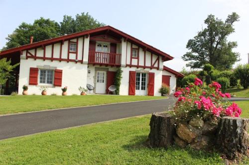 a red and white house with flowers in front of it at Igelseta in Irissarry