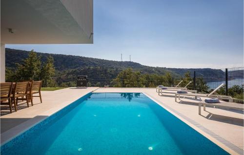 a swimming pool with chairs and a view of a mountain at Villa Adria Blue in Bakarac