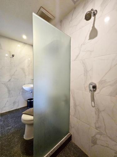 a bathroom with a toilet and a glass shower door at Hotel 88 Kedungsari - Kedungdoro By WH in Surabaya