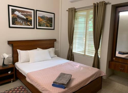 a bedroom with a bed and a window at Home Away From Home in Kolhapur