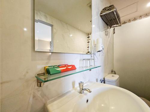 a bathroom with a sink and a mirror and a toilet at Hotel 88 Kedungsari - Kedungdoro By WH in Surabaya