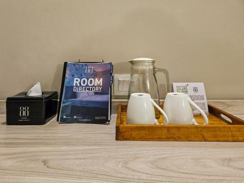 a wooden tray with two mugs and a jar on a table at Hotel 88 Kedungsari - Kedungdoro By WH in Surabaya