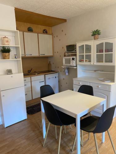 une cuisine avec une table et des chaises dans une pièce dans l'établissement Les Cimes de Belle Hutte, à La Bresse