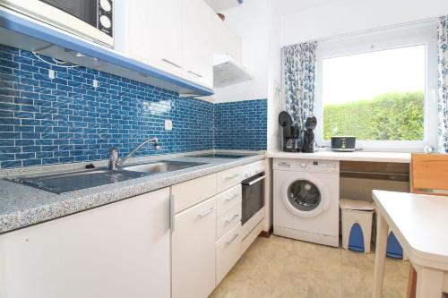 una cocina con fregadero y lavadora en Bungalow-Cara, en Norddeich