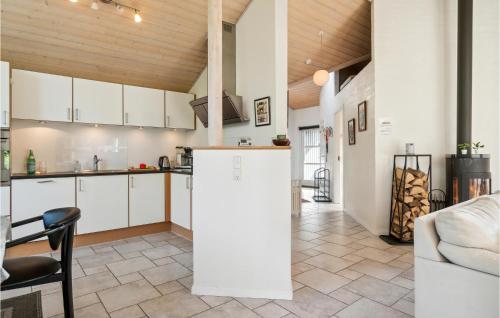 a kitchen with white cabinets and a table and chairs at Holiday Home Sivsangervej Ebeltoft Iii in Øksenmølle