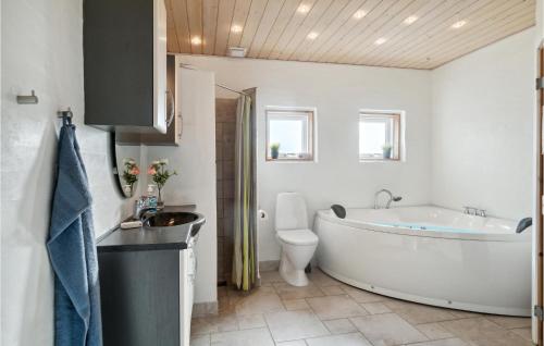 a bathroom with a tub and a toilet and a sink at Holiday Home Sivsangervej Ebeltoft Iii in Øksenmølle
