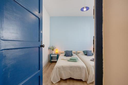 a bedroom with two beds and a blue door at Un jardin al mar in Genovés