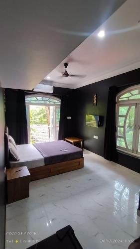 a bedroom with a bed and a ceiling fan at Hotel Harmony By Heaven in Calangute