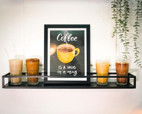 a shelf with a picture of a coffee is a hug in a mug at Paprika Stays Panjim Donapaula in Panaji