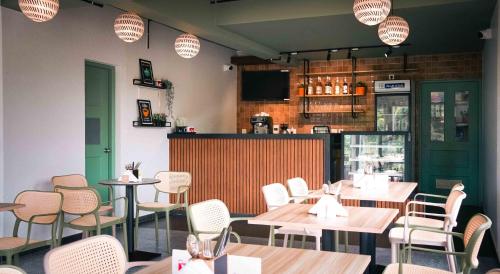 a restaurant with tables and chairs and a bar at Paprika Stays Panjim Donapaula in Panaji