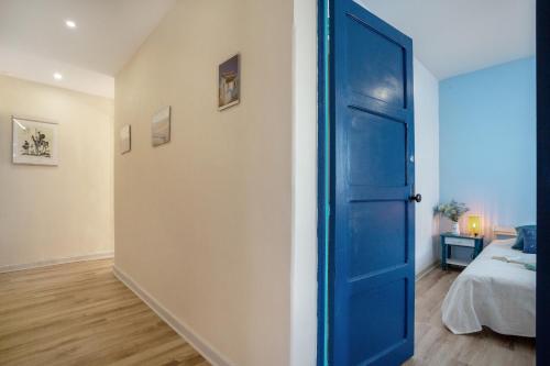 an open blue door in a bedroom with a bed at Un jardin al mar in Genovés