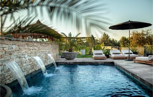 - une piscine avec 2 fontaines et un parasol dans l'établissement Villa Merapi, à Sveti Lovreč Pazenatički