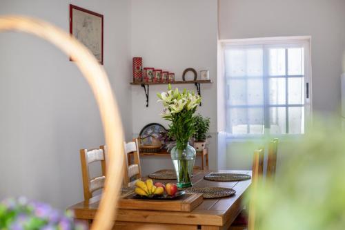 a dining room table with a vase of flowers on it at Un jardin al mar in Genovés