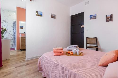 a bedroom with a bed with a pink blanket and towels at Un jardin al mar in Genovés