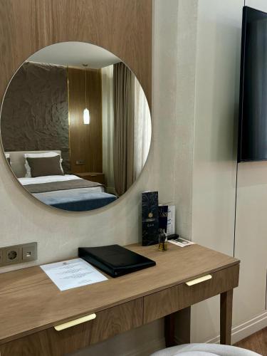 a bedroom with a bed and a mirror at Donatello Boutique Hotel in Almaty