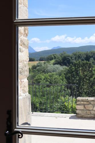 a window looking out at a view of the mountains at Château Les Oliviers de Salettes in Charols