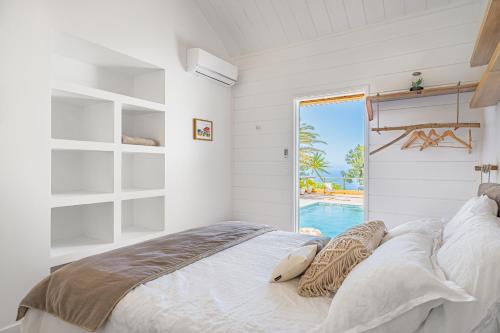 a bedroom with a bed with a view of a pool at Villa Ô in Les Avirons