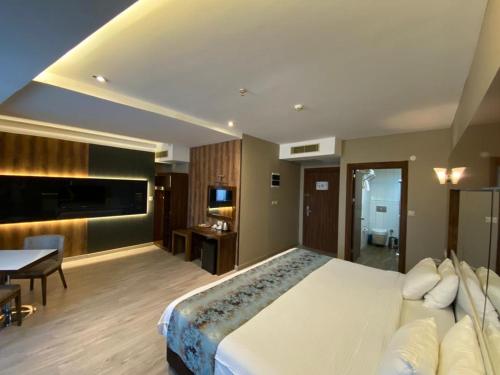 a large bedroom with a large bed and a table at Yucel Hotel in Usak