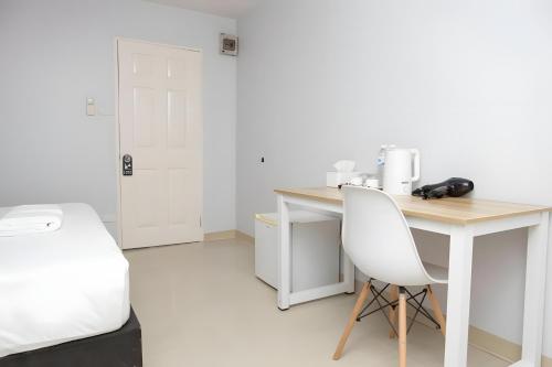 a white desk with a white chair in a room at Elite Hotel Nana Sukhumvit 3 in Bangkok