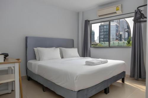 a bedroom with a large bed and a window at Elite Hotel Nana Sukhumvit 3 in Bangkok
