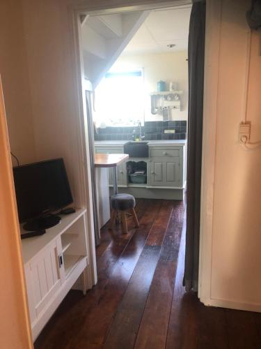 a small kitchen with a table and a television at Appartement in schuur in Twisk