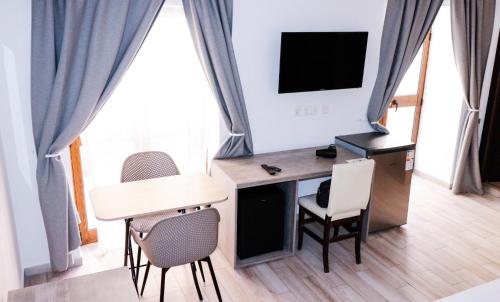TV a/nebo společenská místnost v ubytování Napoli Suites Studios Aparthotel