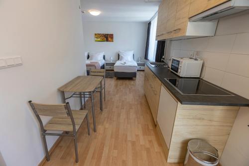 a kitchen with a table and chairs and a couch at Harangtorony Szálló in Kőszeg