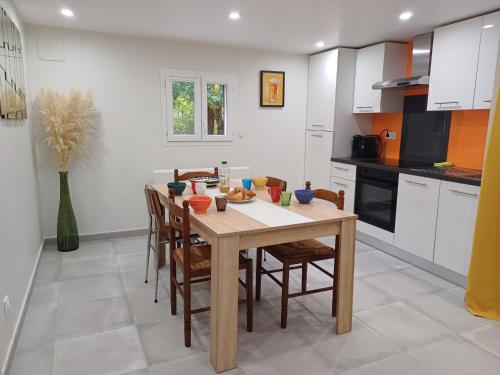 une cuisine avec une table et des chaises en bois dans l'établissement Maisonnette entre mer et lac, à Prades-sur-Vernazobre