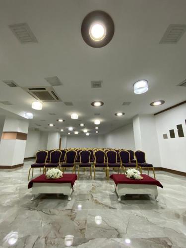 a row of chairs in a waiting room with flowers at Yucel Hotel in Usak
