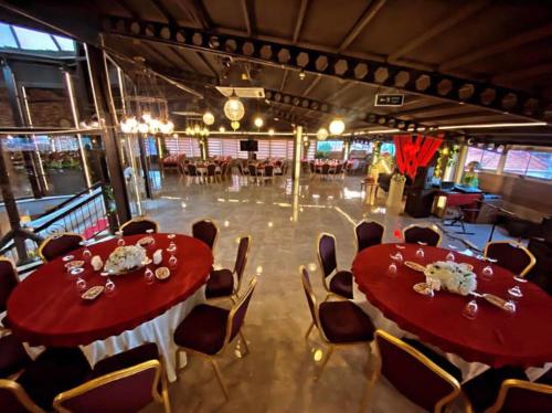 a dining room with two red tables and chairs at Yucel Hotel in Usak