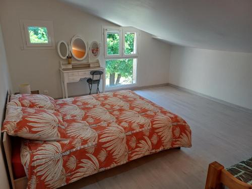 une chambre avec un lit, un bureau et une fenêtre dans l'établissement Maisonnette entre mer et lac, à Prades-sur-Vernazobre