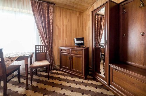 a room with a table and a chair and a mirror at Готель Ольга in Tatariv