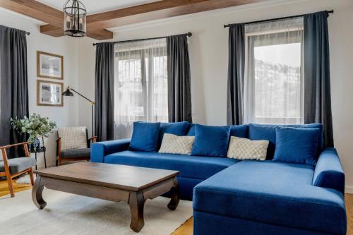 a living room with a blue couch and a coffee table at Duplex Vidik B30 - 85m2 in Kopaonik