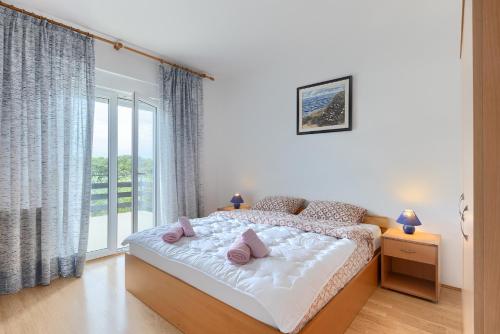 sypialnia z łóżkiem z różowymi poduszkami w obiekcie Apartments Erla w mieście Banjole