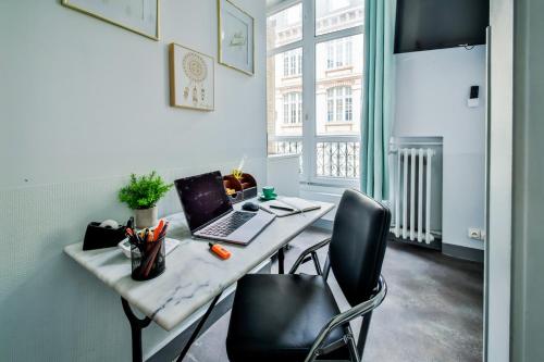 un bureau avec un bureau, un ordinateur portable et deux chaises dans l'établissement WS Louvre - Etienne Marcel, à Paris