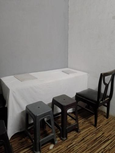 a table with two chairs and a table with a white tablecloth at Bapuji Dormitory Hostel Mumbai in Mumbai