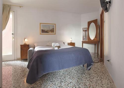een slaapkamer met een bed met een blauwe deken erop bij NK Venice Apartment in Venetië