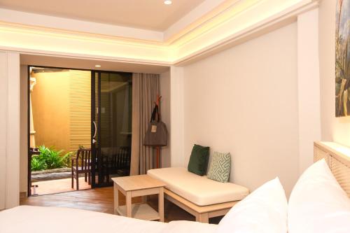 a bedroom with a bed and a chair and a table at Beyond Kata in Kata Beach