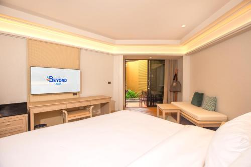 a hotel room with a bed and a television at Beyond Kata in Kata Beach