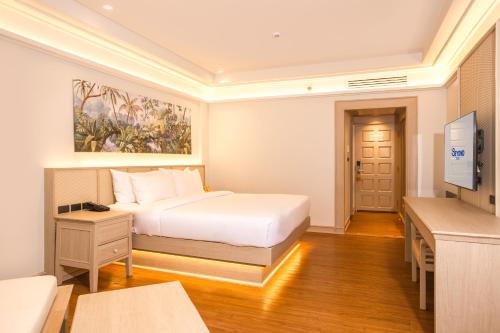 a hotel room with a bed and a television at Beyond Kata in Kata Beach