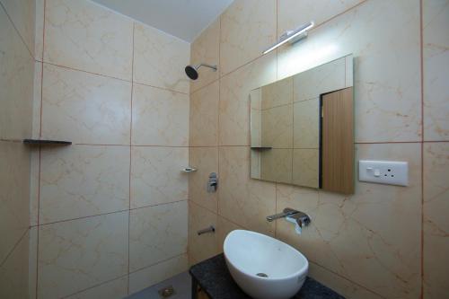 a bathroom with a sink and a mirror at Lykke Suites- 2-min Drive to Colva Beach-By Goan Felicidade Hospitality PVT LTD in Colva