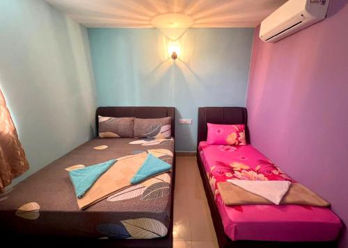 two beds in a room with pink and blue walls at ARK Business Rawang hotel in Rawang