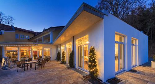 a house with a patio with a table and chairs at Vitalhotel Sonneck in Bad Wörishofen