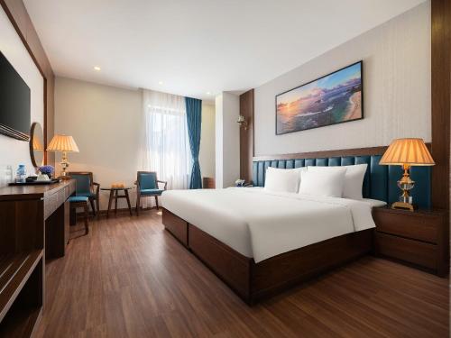 a hotel room with a large bed and a desk at Halong Boutique Hotel in Ha Long