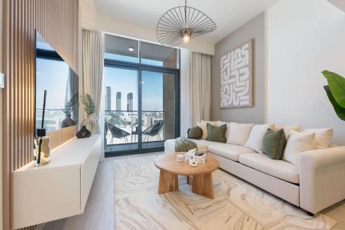 a living room with a couch and a table at Free housekeeping visits during your stay - StayShort - Modern 1-Bedroom Apartment at Azizi Riviera in Meydan in Dubai
