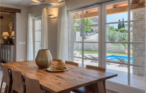 a dining room with a wooden table and a large window at Villa Julia Marija in Poreč